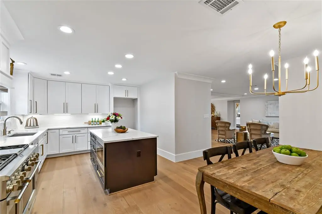 Open-concept kitchen with white cabinets and dark island